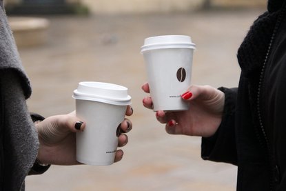zwei Hände mit Kaffee to-go Bechern